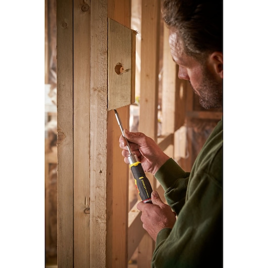Photo du tournevis à cliquet STANLEY FMHT0-62691 utilisé pour visser dans une structure en bois.