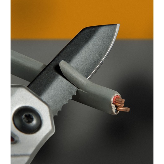 STANLEY FMHT0-72414 gekarteld mes knipt grijze elektriciteitsdraad, close-up.
