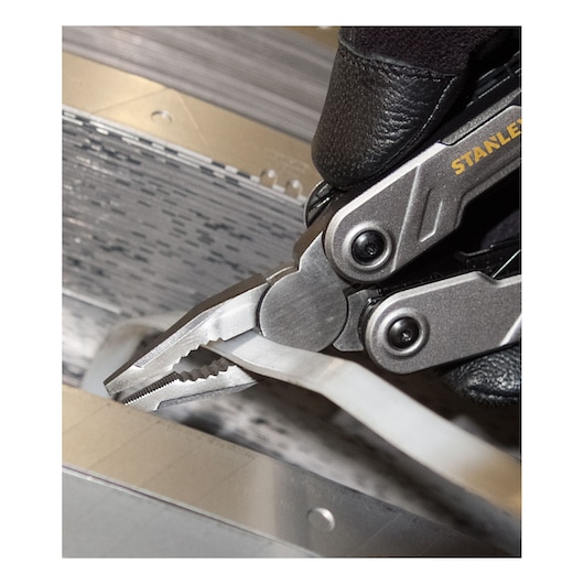 STANLEY FMHT0-72414 multitool tang klemt een witte kabel, close-up foto.
