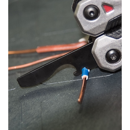 STANLEY FMHT0-72414 tang close-up waarmee koperdraad wordt gestript op donkere ondergrond.
