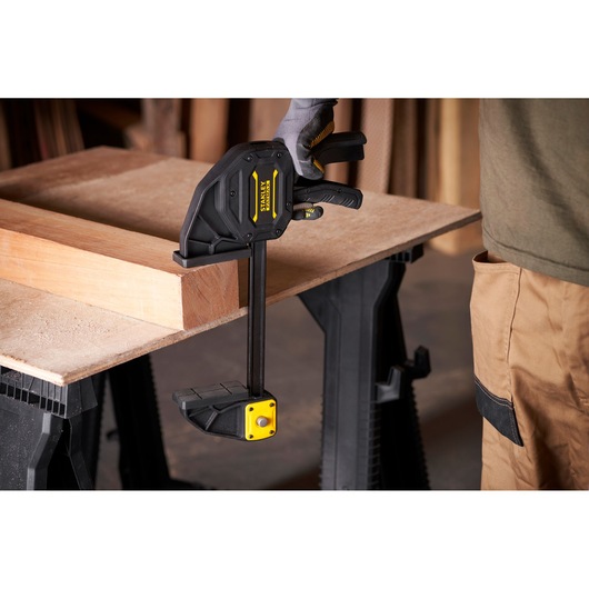 Stanley FMHT0-83238 serre-joint à gâchette fixant du bois sur établi, vue latérale.