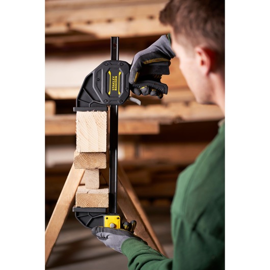 STANLEY FMHT0-83239 photographie d’un serre-joint rapide maintenant des blocs de bois en atelier.