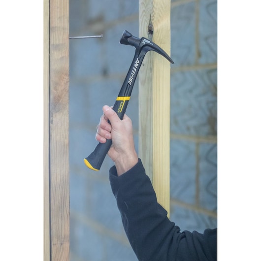 Stanley FMHT1-51277 klauwhamer in gebruik, zwart met gele handgreep, bouwlocatie.