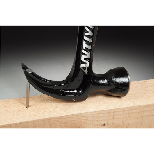 STANLEY FMHT1-51277 klauwhamer zijaanzicht verwijdert spijker uit houten plank.