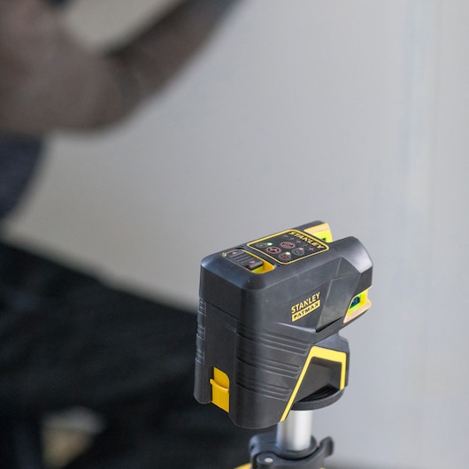 STANLEY FMHT1-77414 laserwaterpas zwart en geel op statief, close-up, bouwfotografie.