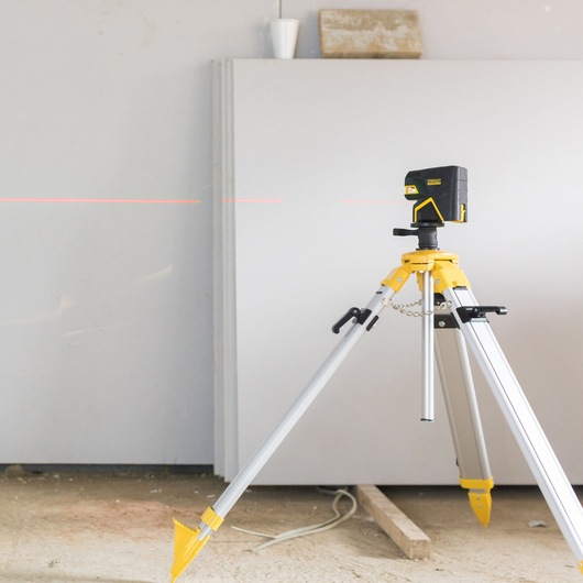 STANLEY FMHT1-77414 laserwaterpas op statief, zijaanzicht, rode laserlijn, bouwfotografie.