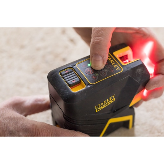 Foto van de STANLEY FMHT1-77415 laser waterpas, met de hand bediend op beige oppervlak.