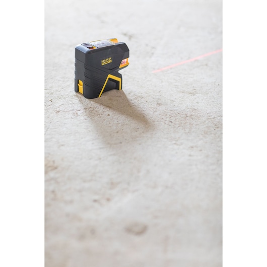 STANLEY FMHT1-77415 laserwaterpas op betonnen vloer met een rode horizontale lijn, zijkant product.