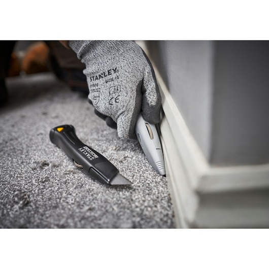 STANLEY FMHT10501-0 couteau utilitaire utilisé pour couper la moquette près de la plinthe, photo en gros plan.