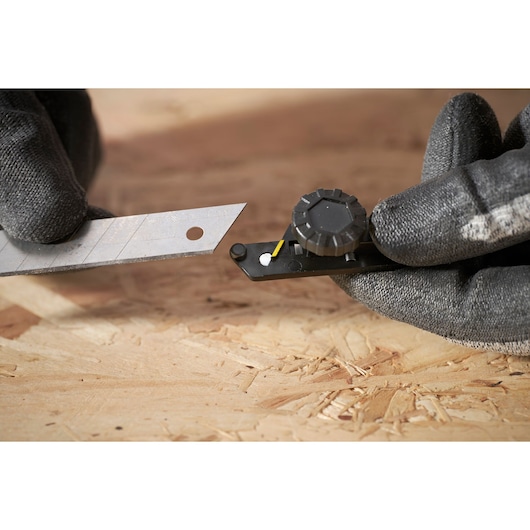 STANLEY FMHT10592-0 outil de casse-lame avec lame, gros plan sur surface en bois.