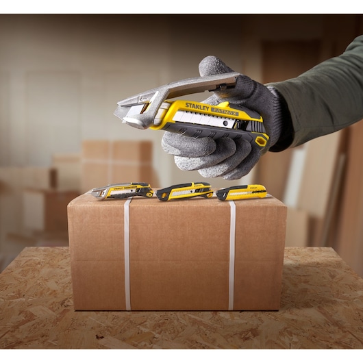 STANLEY FMHT10594-0 hobbymes snijdt doosband, drie messen bovenop, geel met zwart handvat.