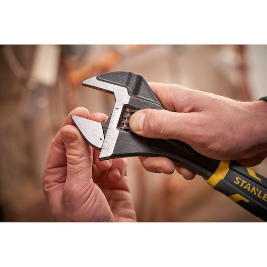 STANLEY FMHT13125-0 verstelbare moersleutel met zwart-gele handgreep in de hand, close-up.
