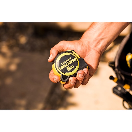Foto van STANLEY FMHT33100-0 FATMAX 5m rolbandmaat in hand, compacte geel-zwarte uitvoering.