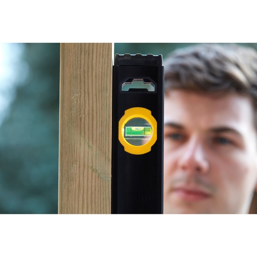 STANLEY FMHT42559-1 fotografie van zwarte en gele waterpas tegen houten paal buiten.