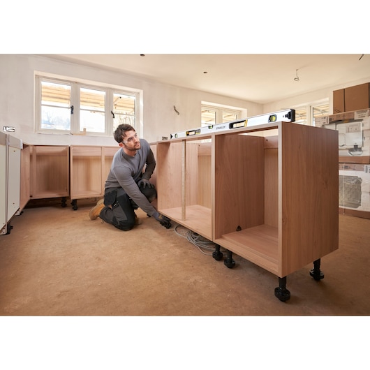 STANLEY FMHT43676-1 waterpas op kasten tijdens installatie, zijaanzicht, lichte keuken in aanbouw.