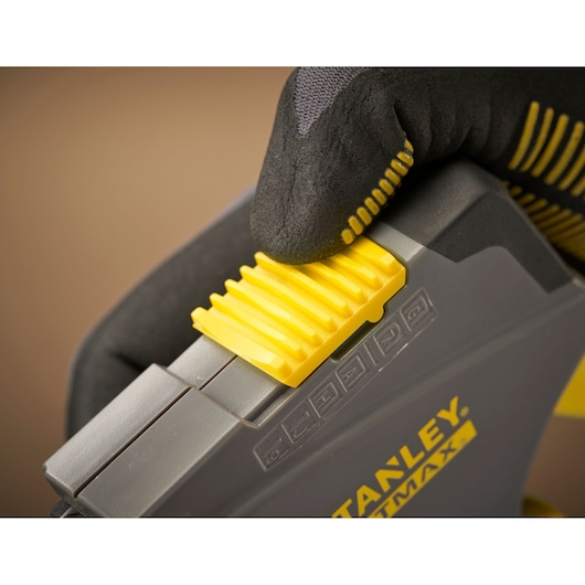 STANLEY FMHT6-70868 photographie d’un outil jaune et gris avec main gantée ajustant un curseur jaune.