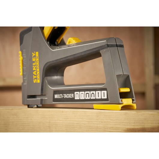 STANLEY FMHT6-70868 agrafeuse multi-tacker vue latérale, noire et jaune, sur surface en bois.