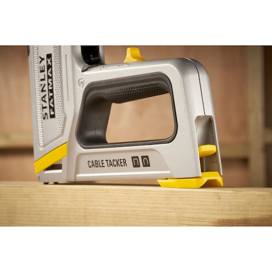 STANLEY FMHT70100-0 câble tacker, argent et jaune, vue de côté sur poutre en bois.
