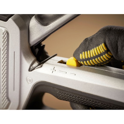 STANLEY FMHT70250-0 photographie gros plan du bouton de réglage sur un outil, main gantée l’utilisant.