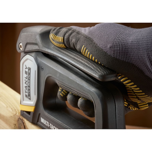 STANLEY FMHT70401-0 agrafeuse tenue par une main gantée sur du bois, vue rapprochée