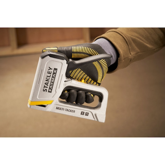 Outil STANLEY FMHT70443-0 multi-tacker argenté tenu par une main gantée.