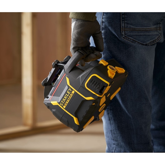 Photo du niveau laser portable STANLEY FMHT77446-1 tenu à la main avec design noir et jaune.