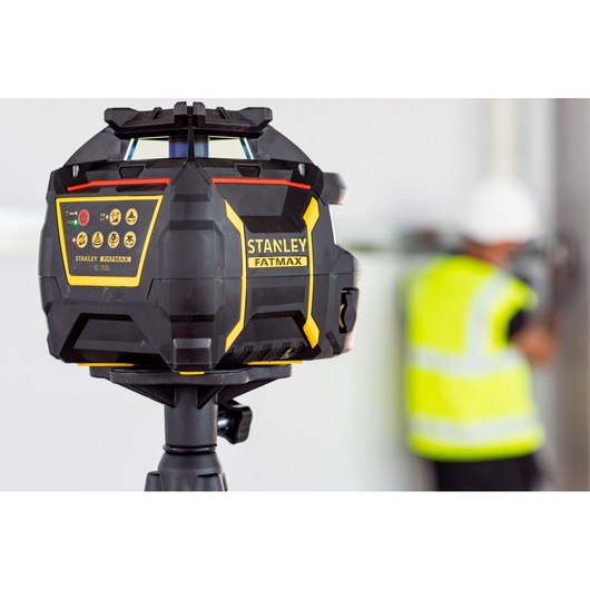 Niveau laser Stanley FMHT77447-1 sur trépied dans un espace intérieur, design noir et jaune.
