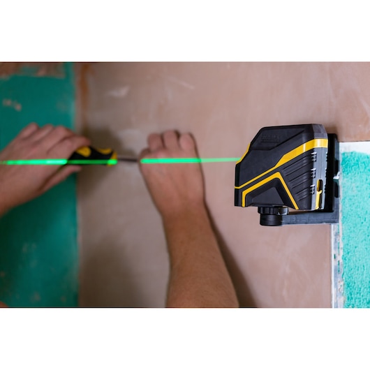 STANLEY FMHT77586-1 laserwaterpas projecteert groene lijn tijdens wandinstallatie.