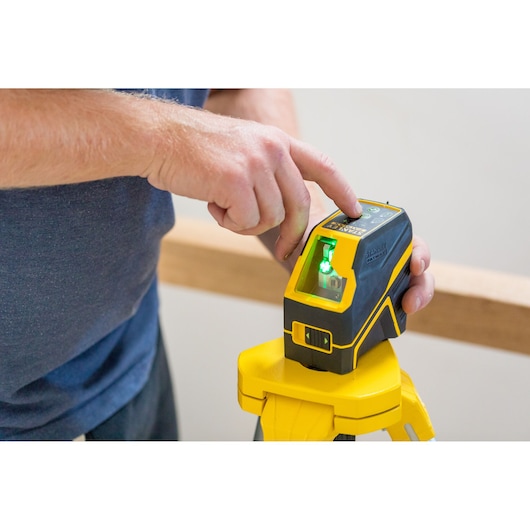 STANLEY FMHT77595-1 laserwaterpas met groen licht op statief, bediend met de hand.