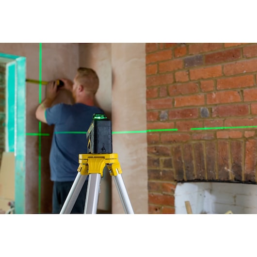 STANLEY FMHT77617-1 laserwaterpas op statief projecteert groene lijnen voor interieurwandmeting.