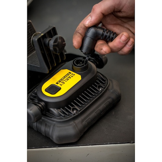 Photo du gonfleur numérique STANLEY FMHT81507-1 branché avec un câble d'alimentation, vue rapprochée.