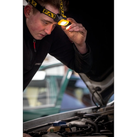 STANLEY FMHT81509-0 hoofdlamp in gebruik, verlicht motorruimte tijdens auto-inspectie.