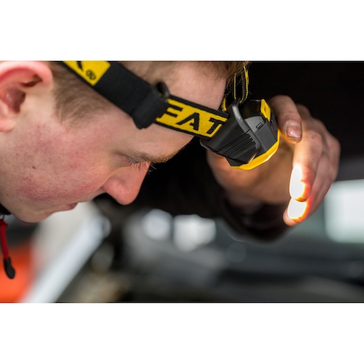 STANLEY FMHT81509-0 hoofdlamp geel en zwart, gedragen bij inspectie, product detailfotografie.