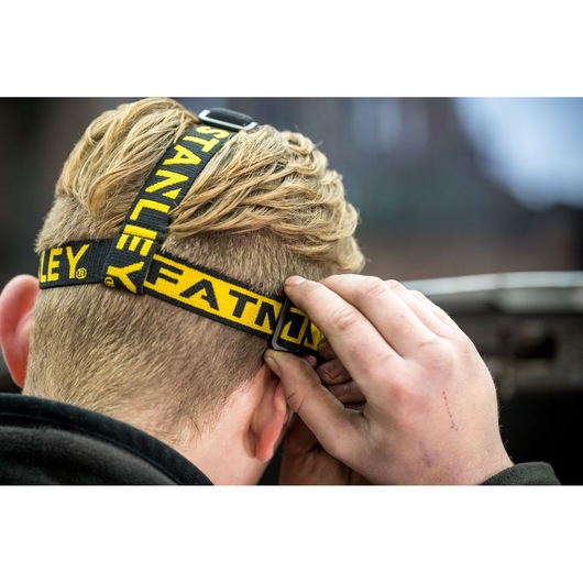Foto van de STANLEY FMHT81509-0 hoofdlamp met verstelbare geel-zwarte band vanaf achteren gezien.