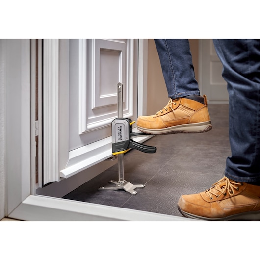 STANLEY FMHT83550-1 deurinstallatiegereedschap klemt kast, werknemer gebruikt voetpedaal, productfotografie.