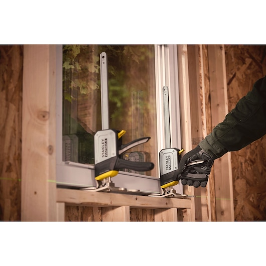 STANLEY FMHT83550-1 metalen lijmklem gebruikt om een raamkozijn te bevestigen tijdens installatie op houten constructie.