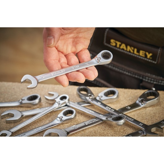 Foto van STANLEY FMMT13087-0 sleutelset, zilveren sleutels op tafel, één in hand gehouden, close-up.