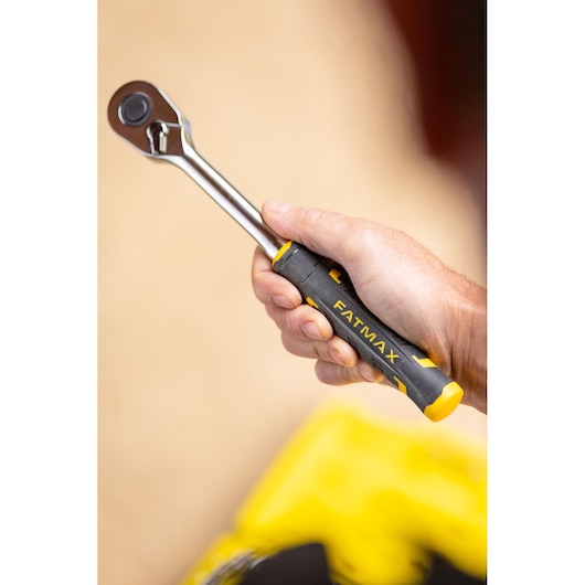 STANLEY FMMT82826-1 ratelsleutel met zwart-gele FATMAX handgreep vastgehouden in hand, close-up.