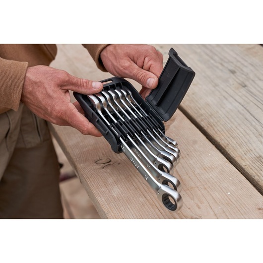 STANLEY FMMT82848-0 jeu de clés à cliquet réversible 7 pièces dans un étui tenu par des mains, photo sur surface bois.