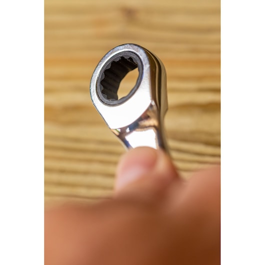 Gros plan sur la clé à cliquet STANLEY FMMT82848-0 tenue à la main, vue de l'extrémité dentée, intérieur.