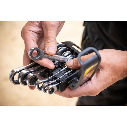 STANLEY FMMT82900-0 jeu de clés mixtes à cliquet tenu dans les mains, vue rapprochée en extérieur.