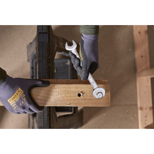 STANLEY FMMT82902-0 sleutel in gebruik bij het aandraaien van een bout op een houten plank, close-up van bovenaf.