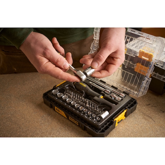 STANLEY FMMT98101-0 dop- en ratelset gefotografeerd in gebruik, zwarte koffer open op werkbank.