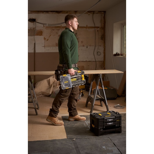 Foto van een werknemer met een STANLEY FMMT98104-0 doppenset in een transparante koffer in een werkplaats.