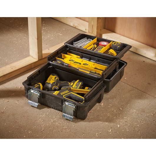 STANLEY FMST1-71219 boîte à outils noire avec compartiments remplie d’outils jaunes, photographie en atelier.