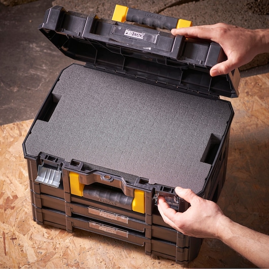 STANLEY FMST1-72365 modulaire opbergbox met schuiminzet, geopend van boven op houten oppervlak.
