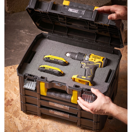 STANLEY FMST1-72365 ProStack gereedschapskist open met geel-zwarte boormachine en twee batterijen in schuim inzet.