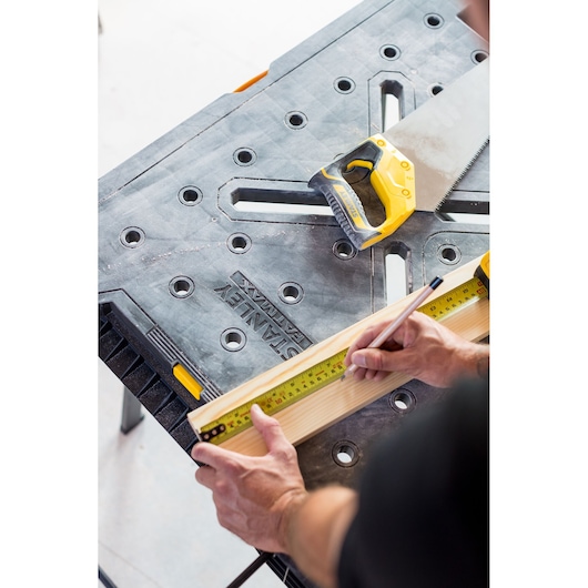 STANLEY FMST1-75672 werkbank met handzaag en meetlint, hout wordt gemarkeerd voor zagen.