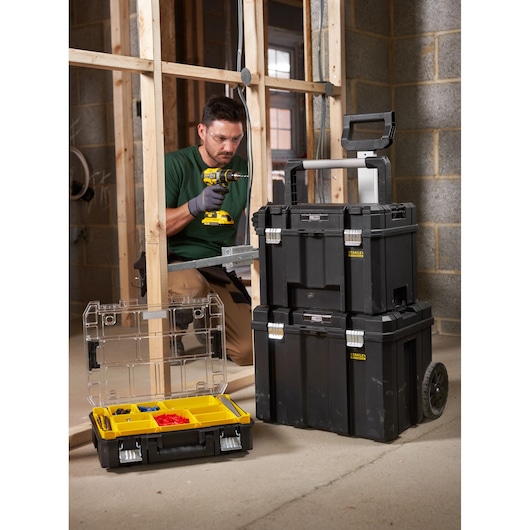 STANLEY FMST1-75753 stapelbare gereedschapskistset en organizerbox op bouwplaats, zwart met gele vakken.