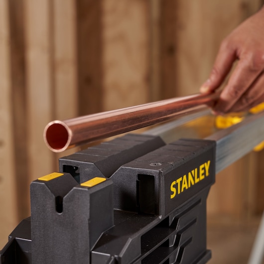 Foto van STANLEY FMST1-75763 werkbank met een koperen buis, close-up.